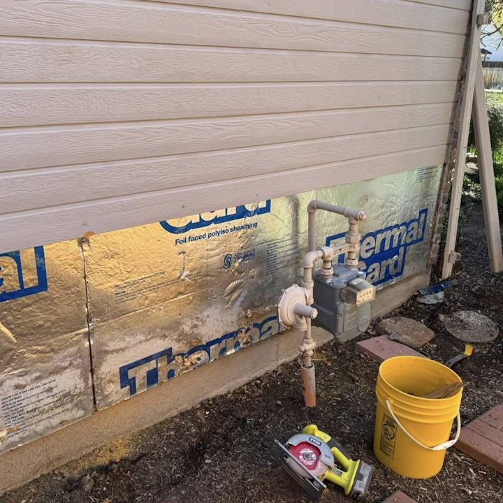 A house corner getting siding repair by JLS Painting